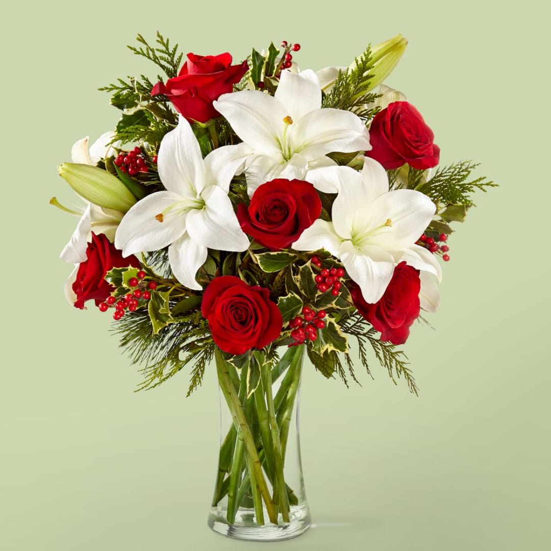 Red roses and white lilies in a clear glass vase
