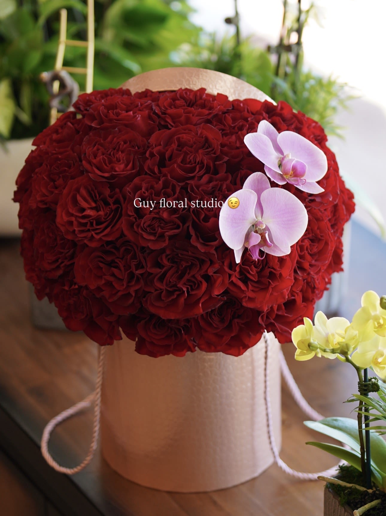 Velvet Red Roses &amp; Orchid Elegance - Experience timeless elegance with our Red Velvet Luxury Roses Box, a breathtaking arrangement of premium deep red roses beautifully designed in a modern hat box and accented with delicate orchids. This luxurious floral design is perfect for romantic occasions, anniversaries, birthdays, or making a bold statement of love and appreciation. Each arrangement is handcrafted with care to deliver a high-end floral experience that stands out. We offer same day flower delivery in Beverly Hills, West Hollywood, Santa Monica, Beverly Grove, Bel Air &amp; Culver City. Order online or call now for fast delivery today. Order today and send a memorable gift that speaks elegance, passion, and luxury. The arrangement shown in the photo reflects our Deluxe size, featuring a fuller, more abundant design with premium blooms.