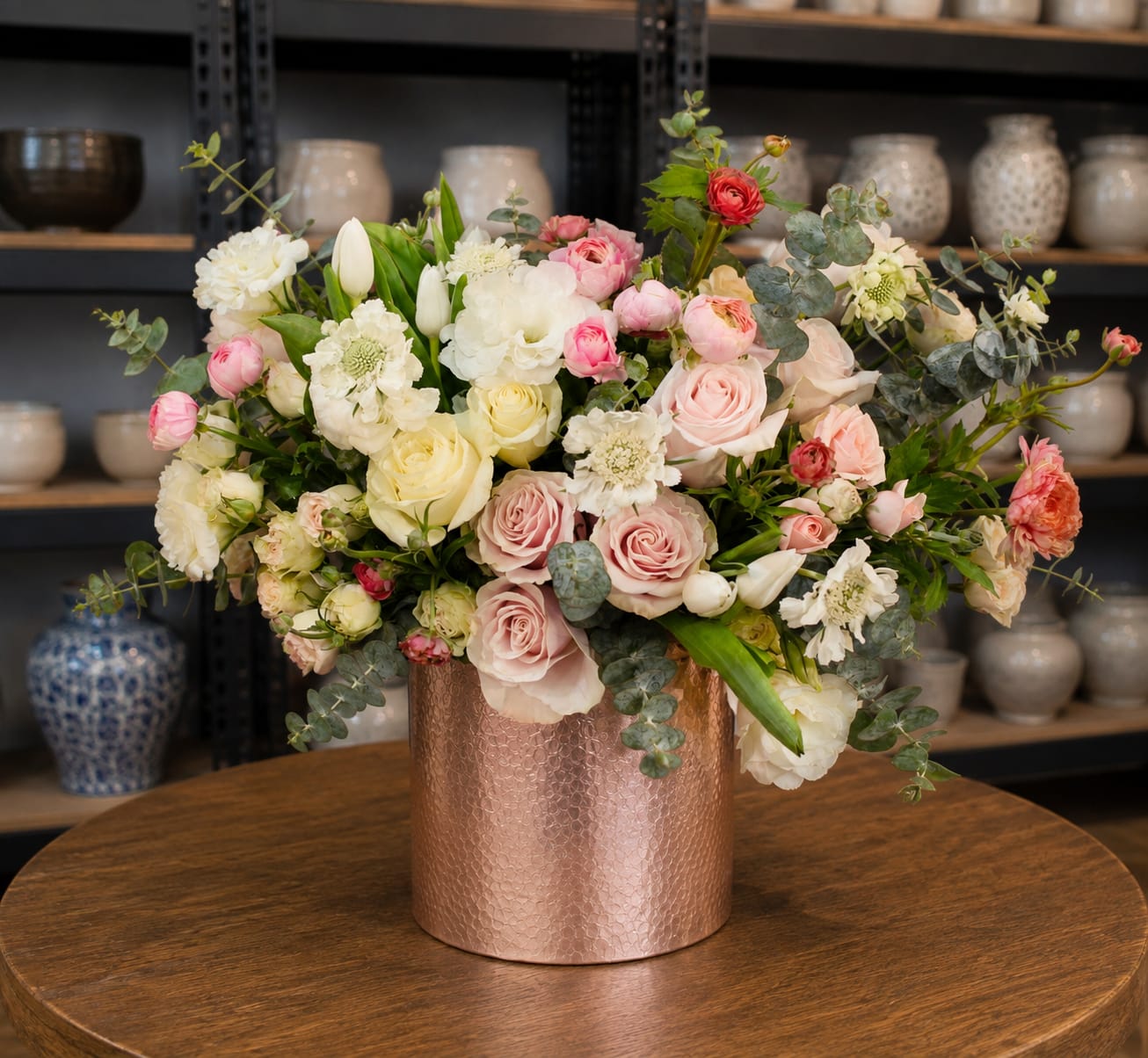Mixed bouquet of pink, white, and cream flowers in a copper vase
