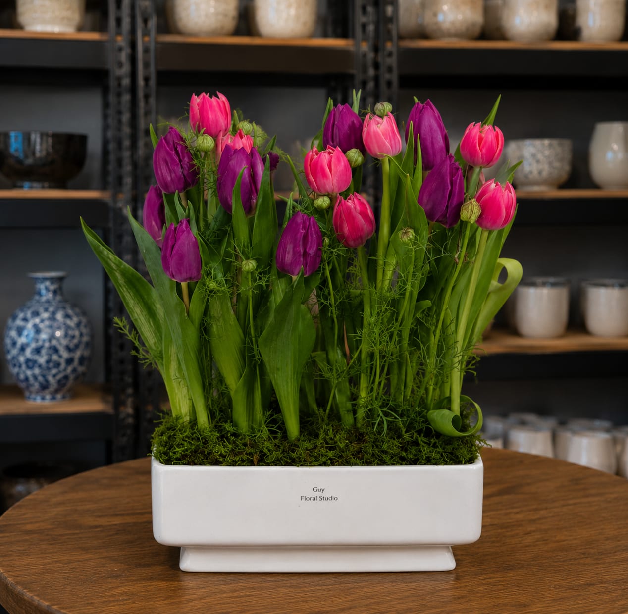 Pink and purple tulips arranged in a white rectangular planter
