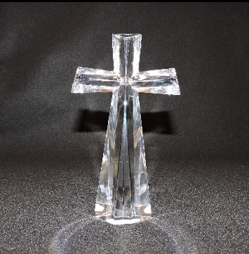 Clear glass cross ornament on a dark background