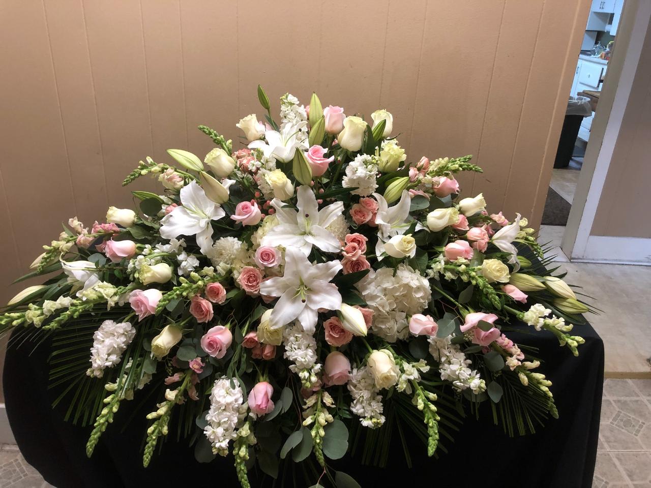 Large white and pink floral casket spray with lilies and roses