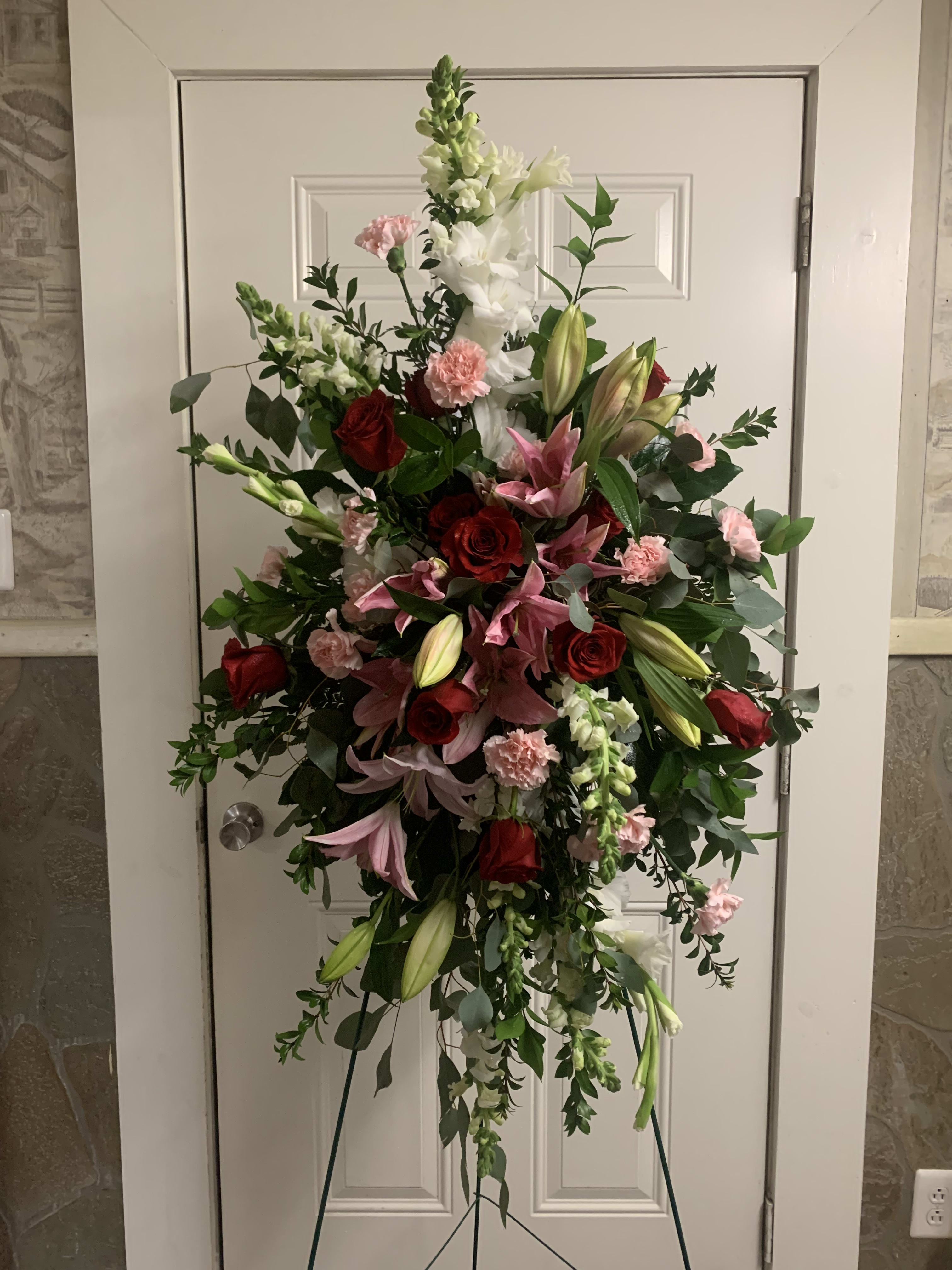Standing floral spray with red roses, pink lilies, and white snapdragons