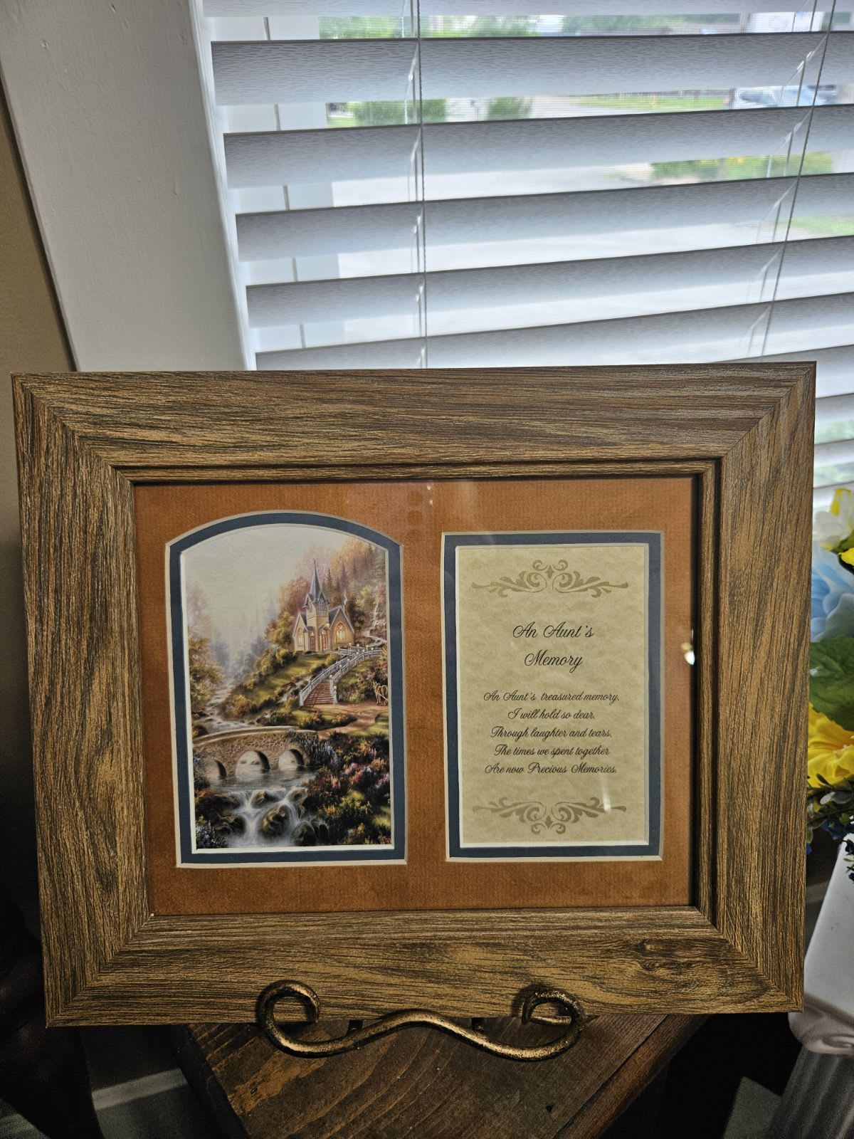 Wooden memorial frame with a printed tribute and landscape scene