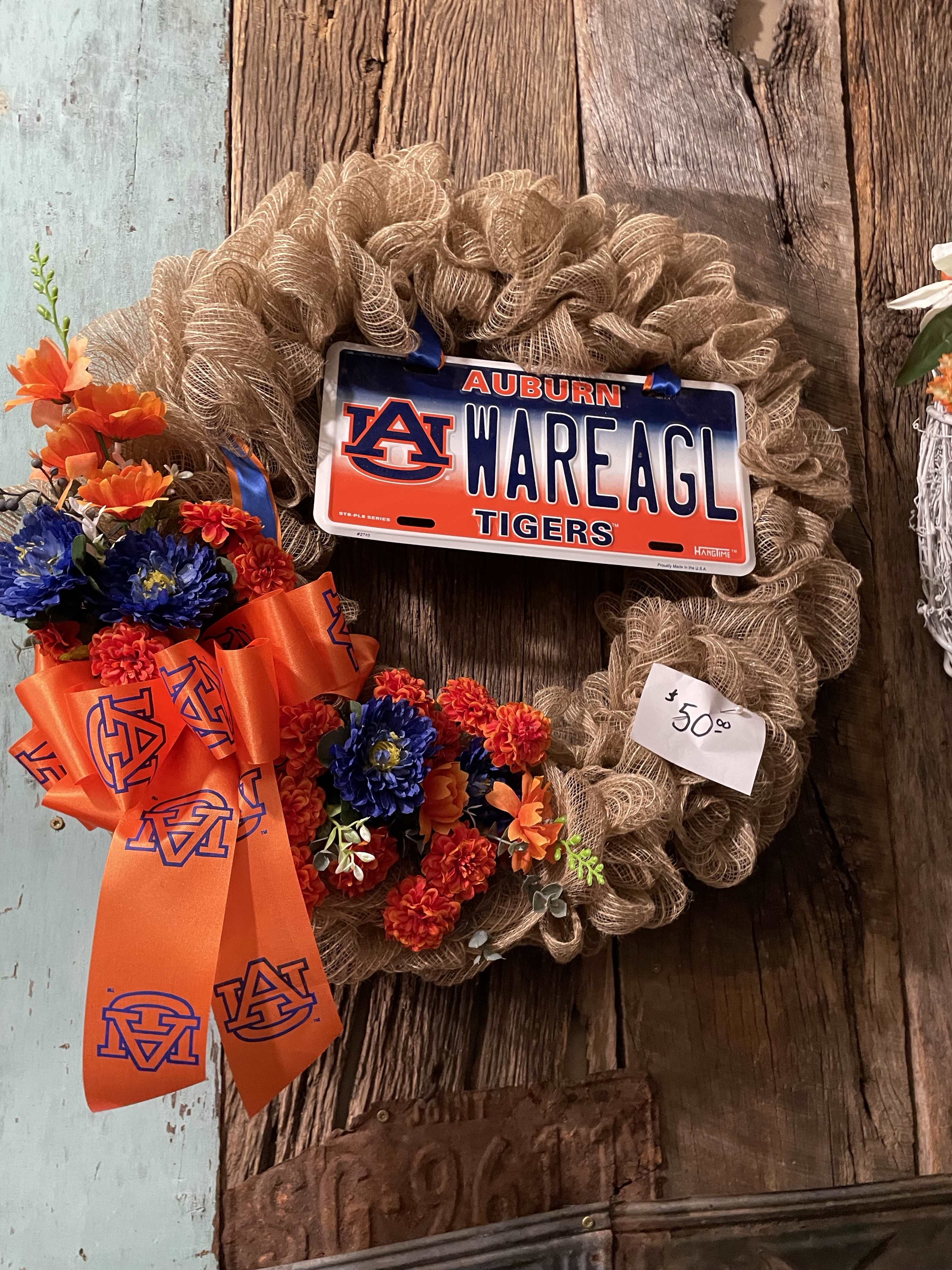 A floral wreath with an Auburn license plate and orange ribbon