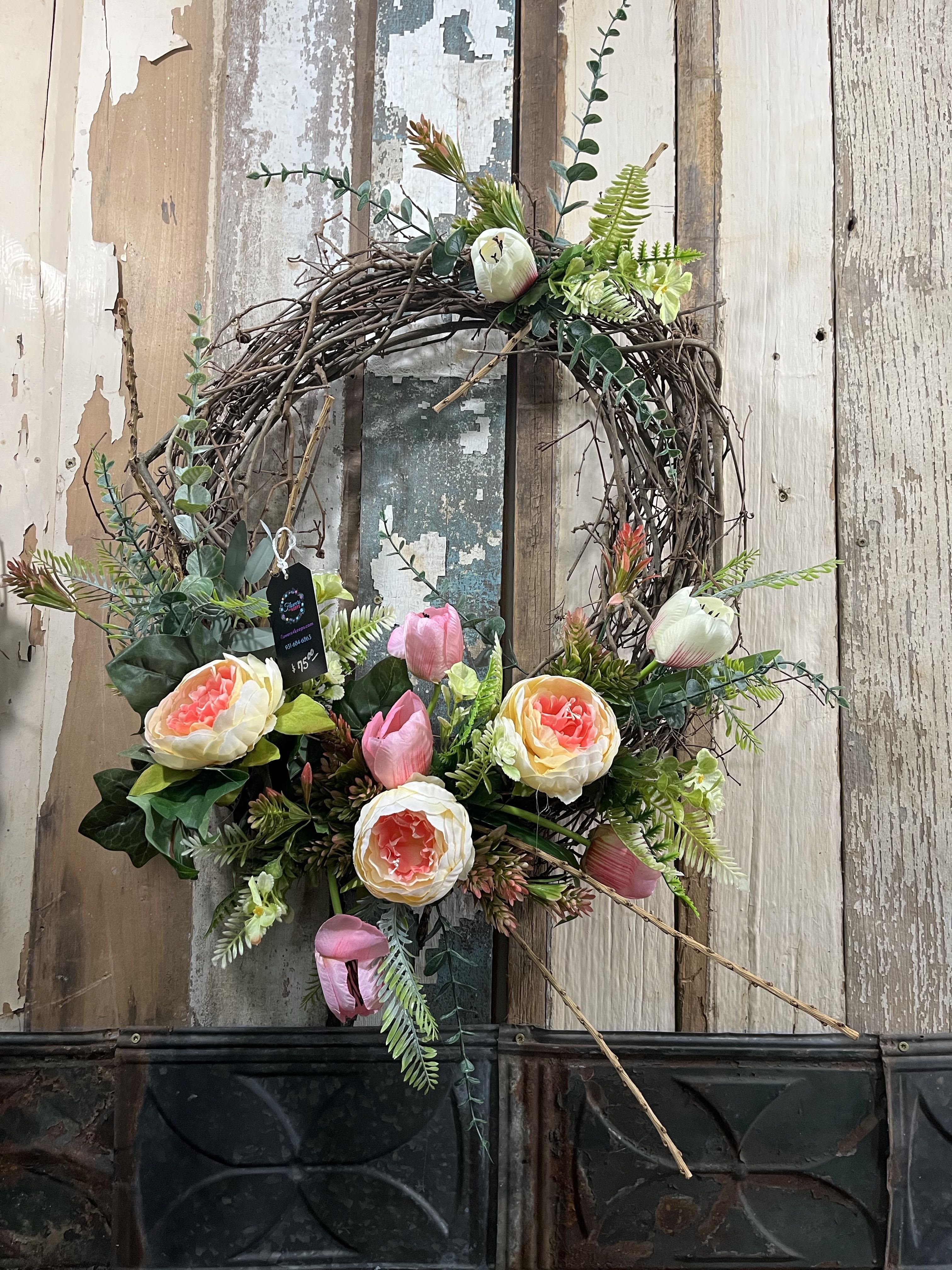 Floral wreath with pink and cream blooms on a twig base