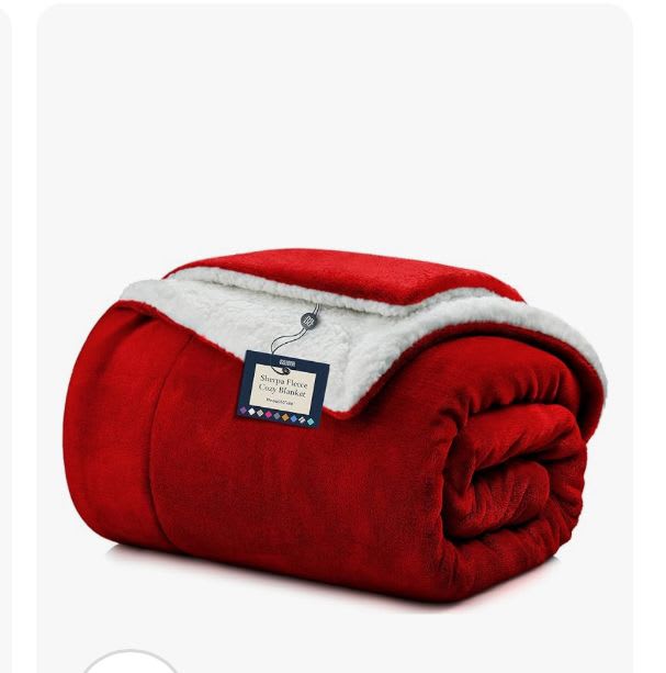 Folded red fleece blanket with white sherpa trim and a hanging tag