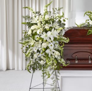 White funeral spray beside a casket