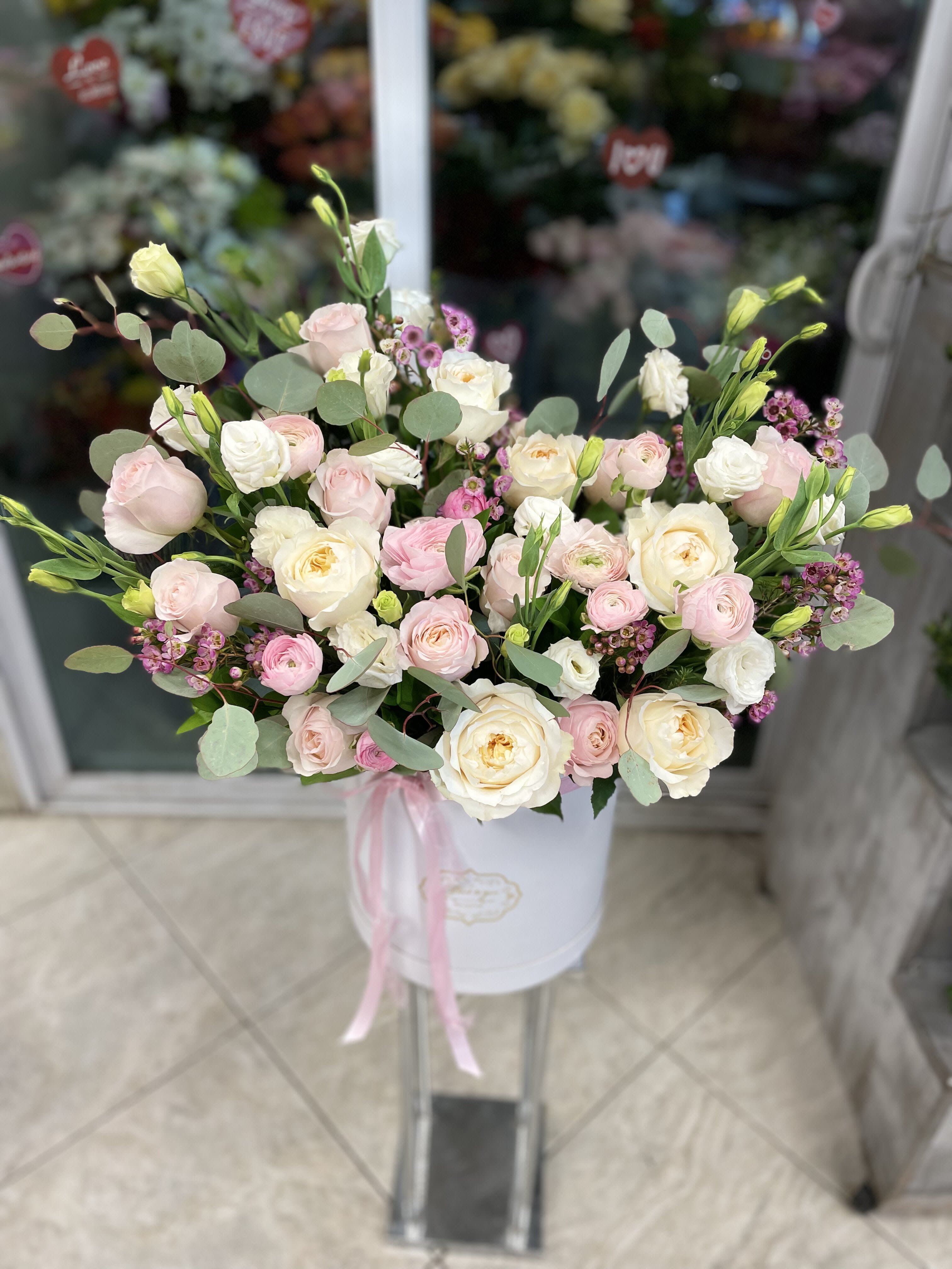Pink and white rose bouquet in a white hat box with ribbon