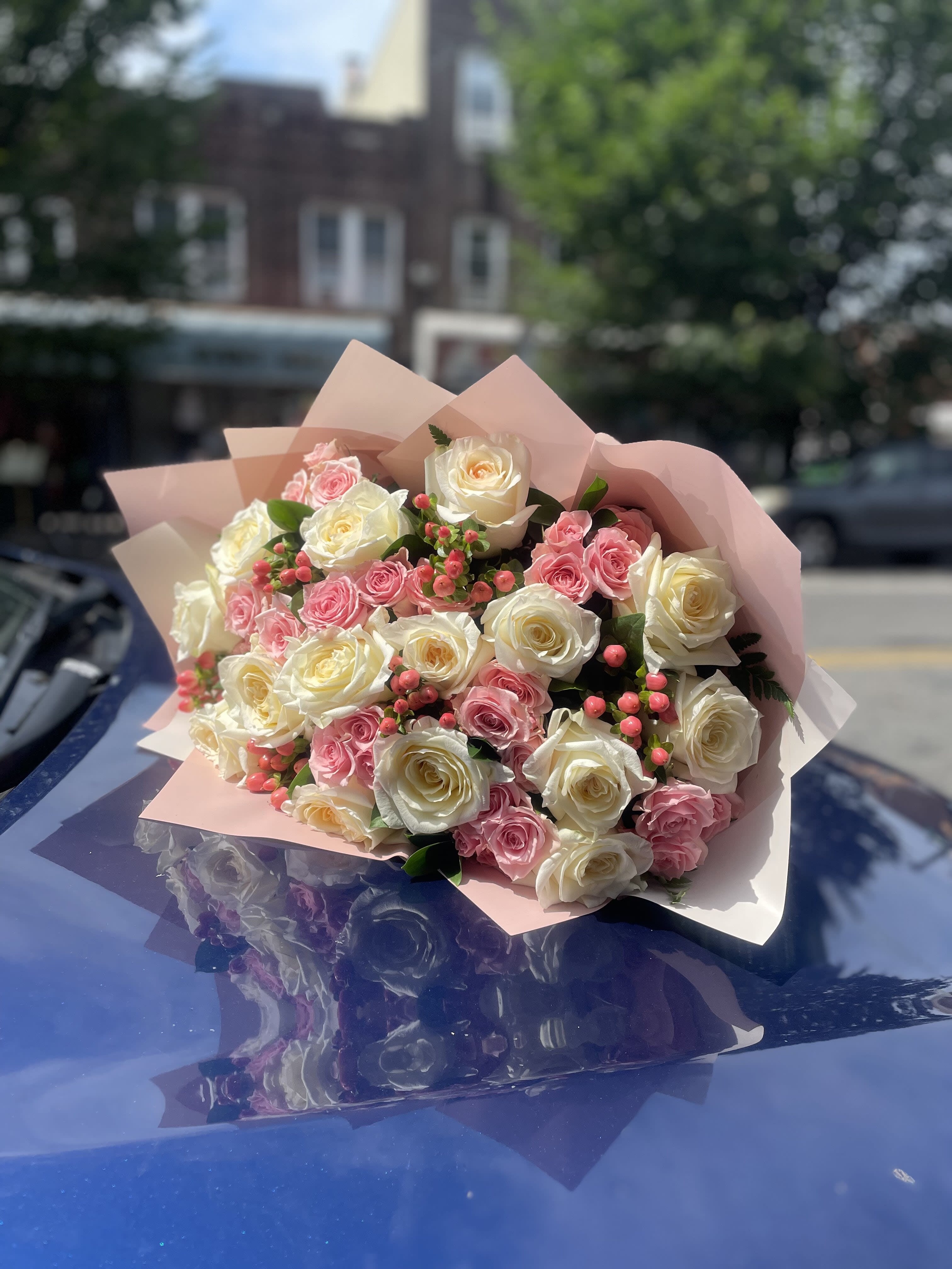 Bouquet of pink and white roses wrapped in pale pink paper