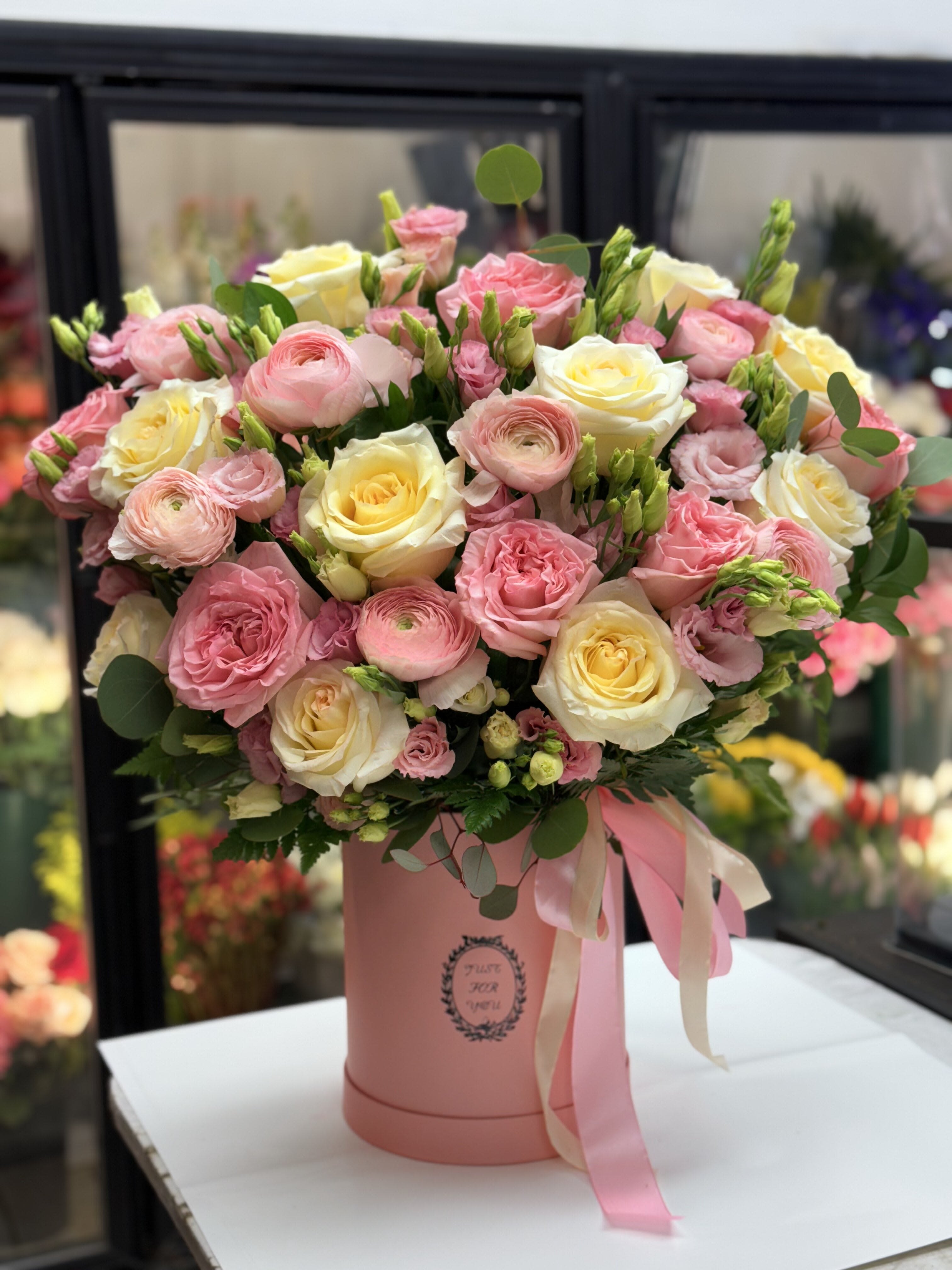 Pink and cream rose bouquet in a pink hatbox with ribbon