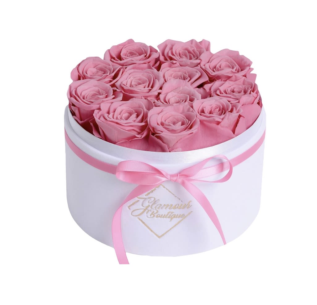 Pink roses arranged in a white round box with a pink ribbon