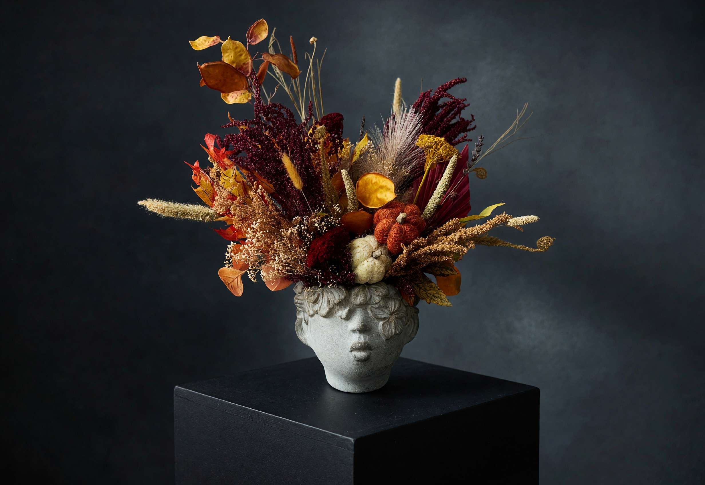 Autumn floral arrangement in a sculpted face vase
