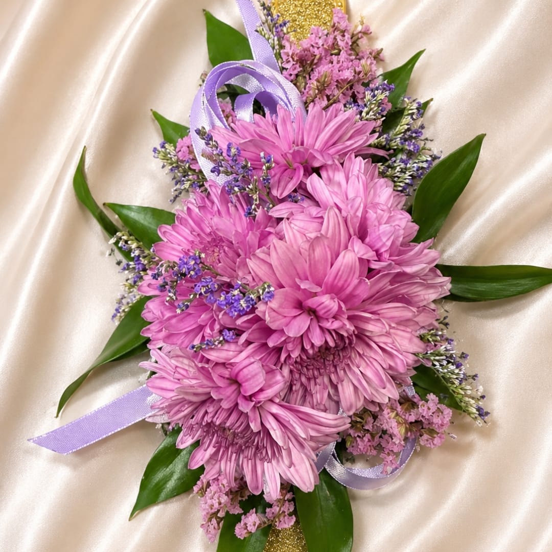 Pink chrysanthemum bouquet with purple ribbon on satin fabric