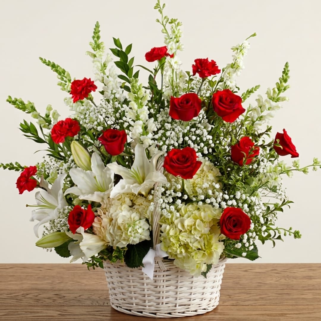 Basket arrangement of red roses, white lilies, and white snapdragons