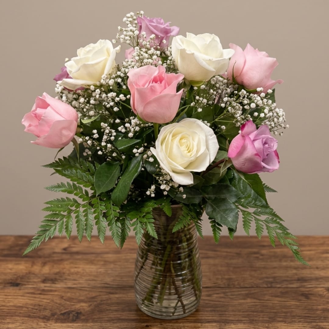 Pink and white roses arranged in a glass vase