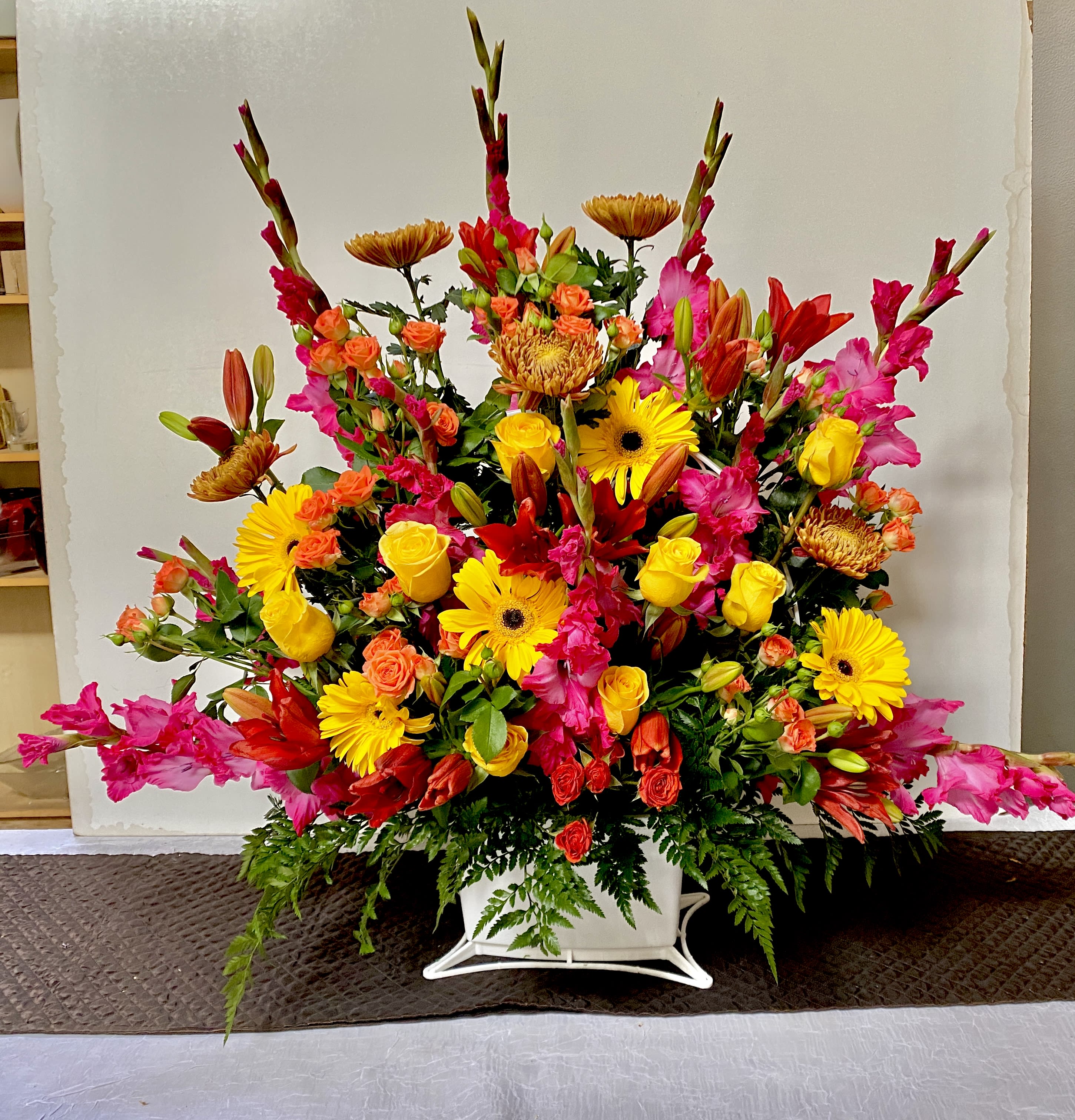 Large colorful floral arrangement in a white container
