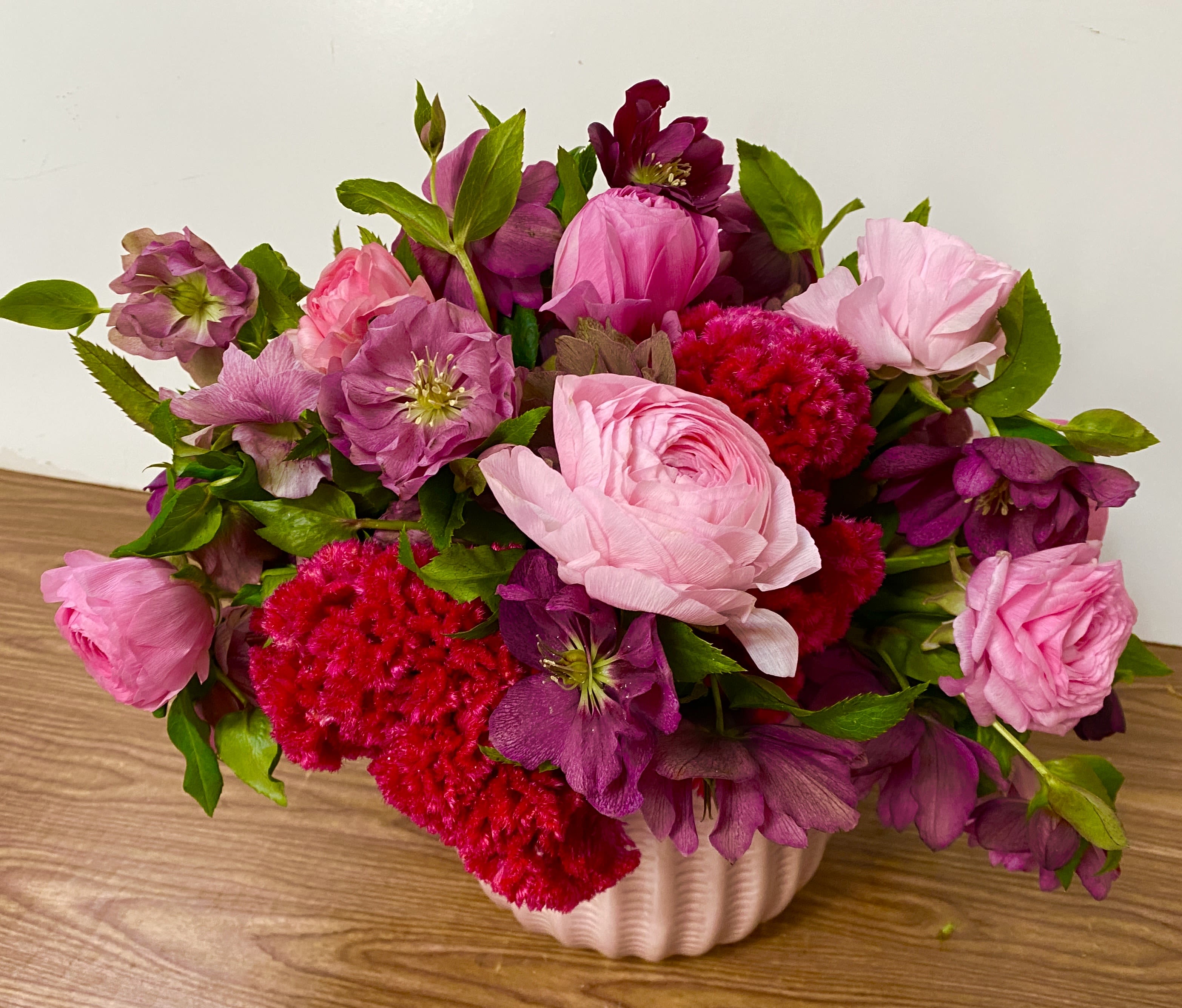 Pink and purple flower arrangement in a white vase