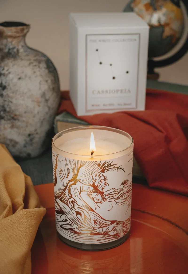 Lit candle in a glass jar with a decorative label