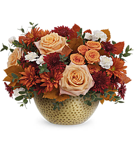 Peach roses and orange mums in a textured gold vase