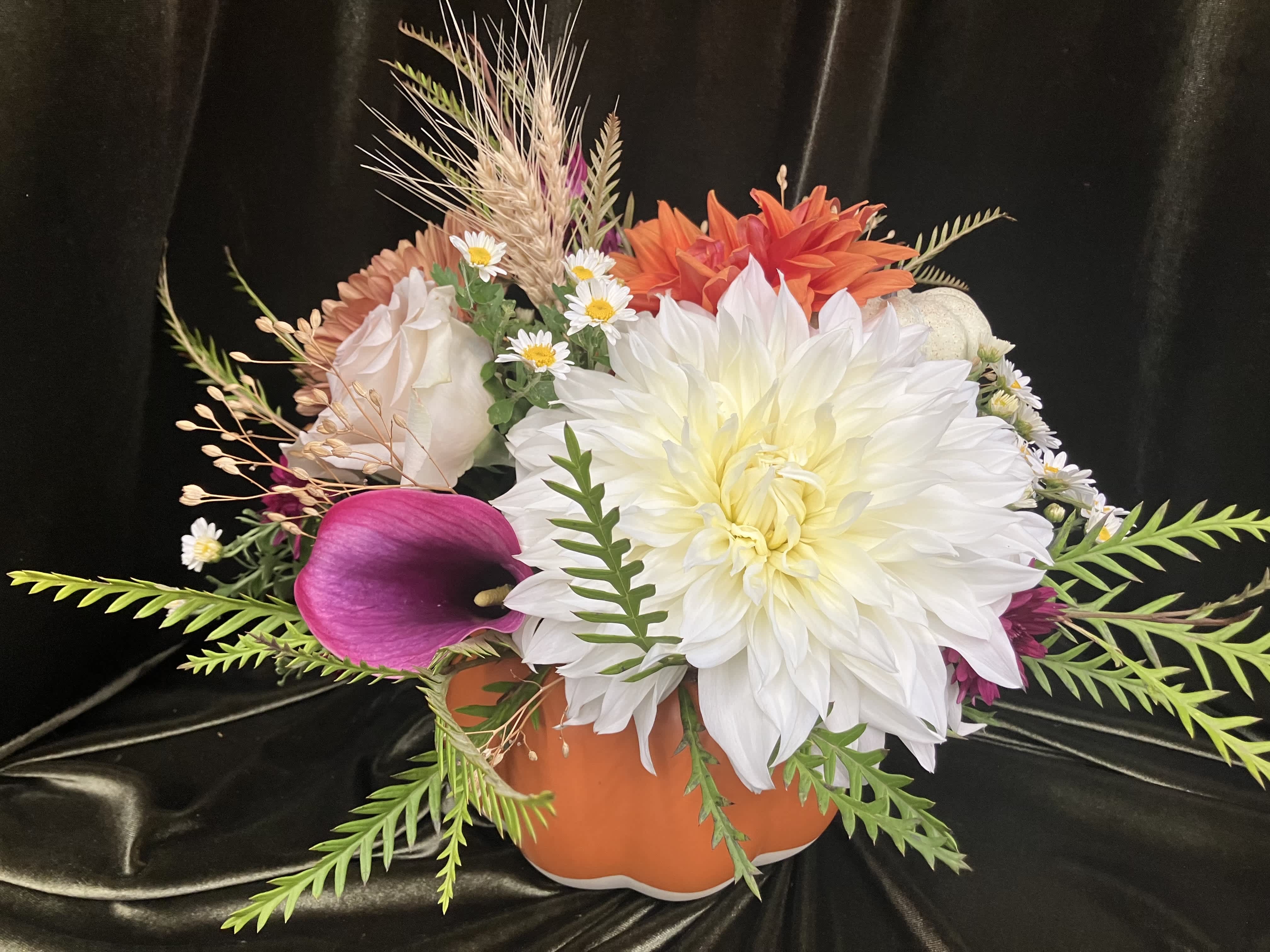 Mixed floral arrangement in an orange pumpkin-shaped container