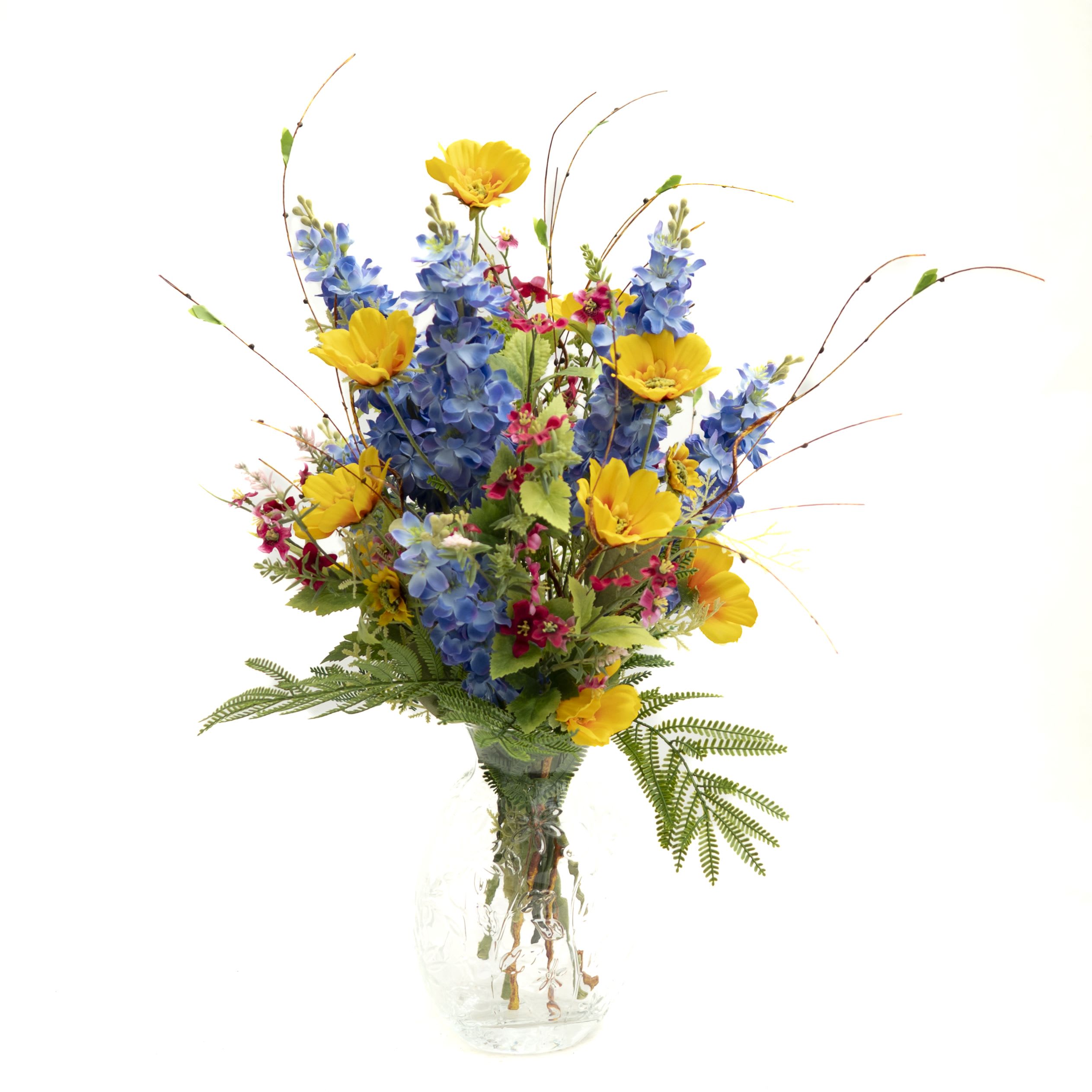 Blue and yellow mixed flower arrangement in a clear glass vase