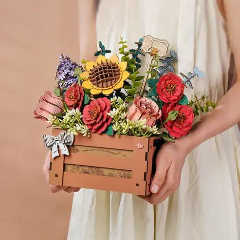 Hands Craft - Bloom Box Wooden 3D Puzzle - This exquisite 3D wooden puzzle features a stunning bouquet of laser-cut flowers, including roses, camellias, sunflowers, lilacs, and delicate fillers. Each flower is meticulously crafted with intricate details, showcasing the natural beauty of the petals, leaves, and stems. The puzzle pieces fit together seamlessly, creating a breathtaking, lifelike floral arrangement that blooms in three-dimensional form. Whether displayed as a work of art or carefully assembled as a tactile challenge, this puzzle offers a rewarding and decorative experience for puzzle lovers and nature enthusiasts alike. Crafted from high-quality wood, it is a durable and charming addition to any collection.  Age Range: 14+  Assembled Dimensions: 11 x 5.5 x 11 inches  Assembly Time: 3 hours  Piece Count: 658