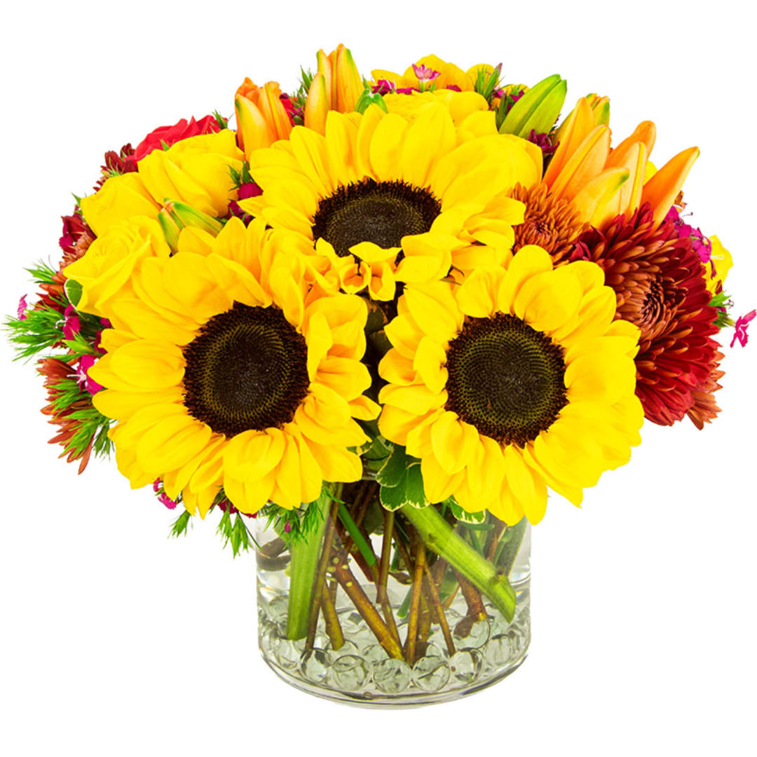 Bouquet of yellow sunflowers and mixed blooms in a clear glass vase