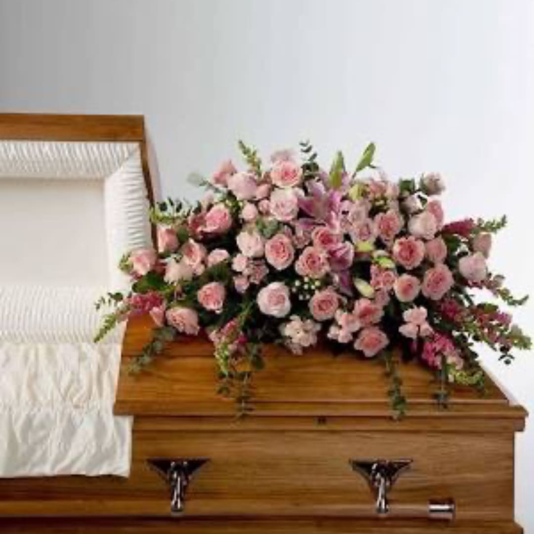 Pink floral spray on a wooden casket