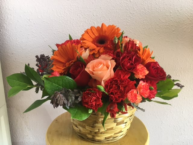 Autumn Breeze by Forever Flowers - A beautiful basket full of fall colored flowers for any occasion.  Contains orange gerberas, red carnations, and red &amp; peach roses.