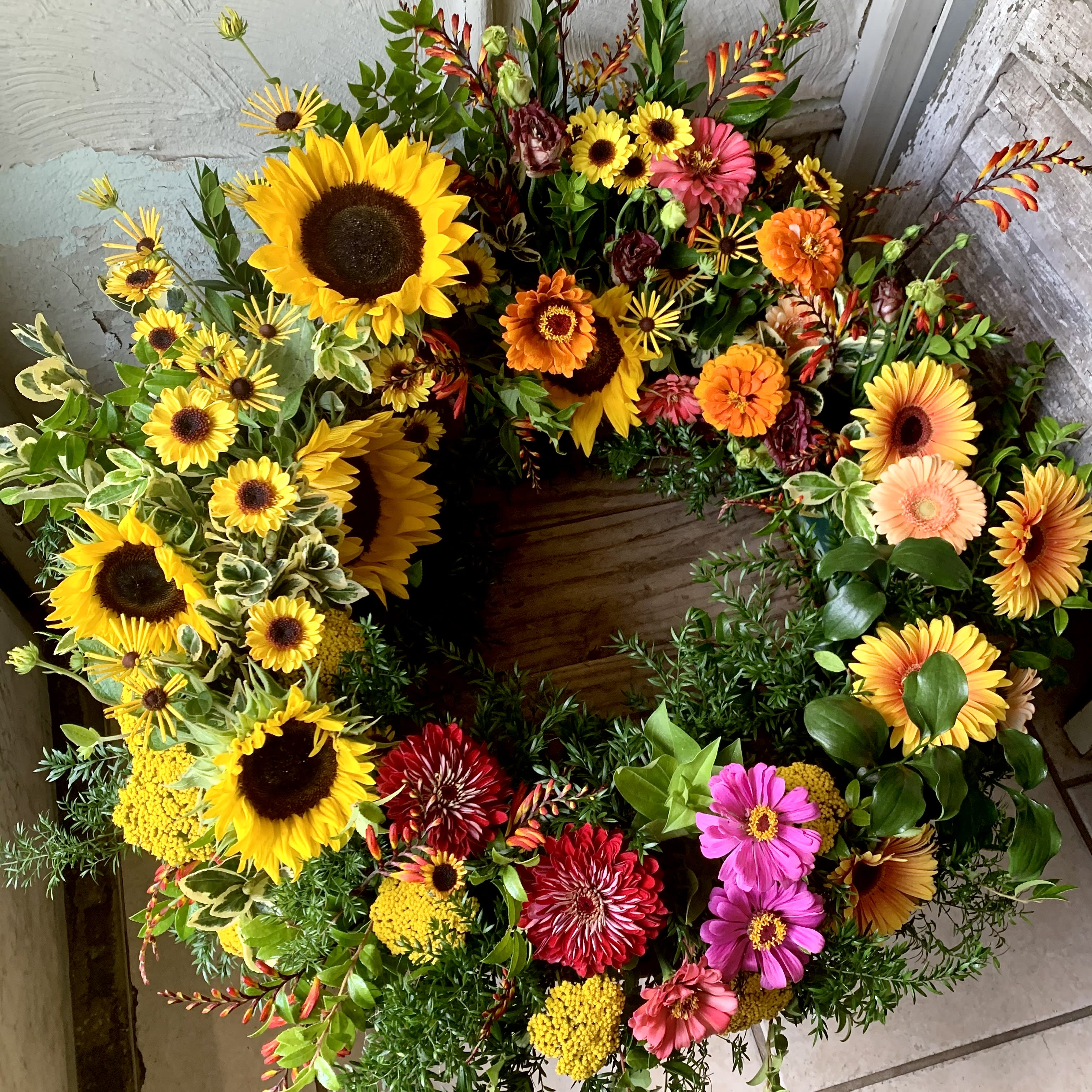 Dawn of Spring  - This colorful arrangement cradles the urn in a vibrant embrace. Colors and flowers may change based off of season and availability.