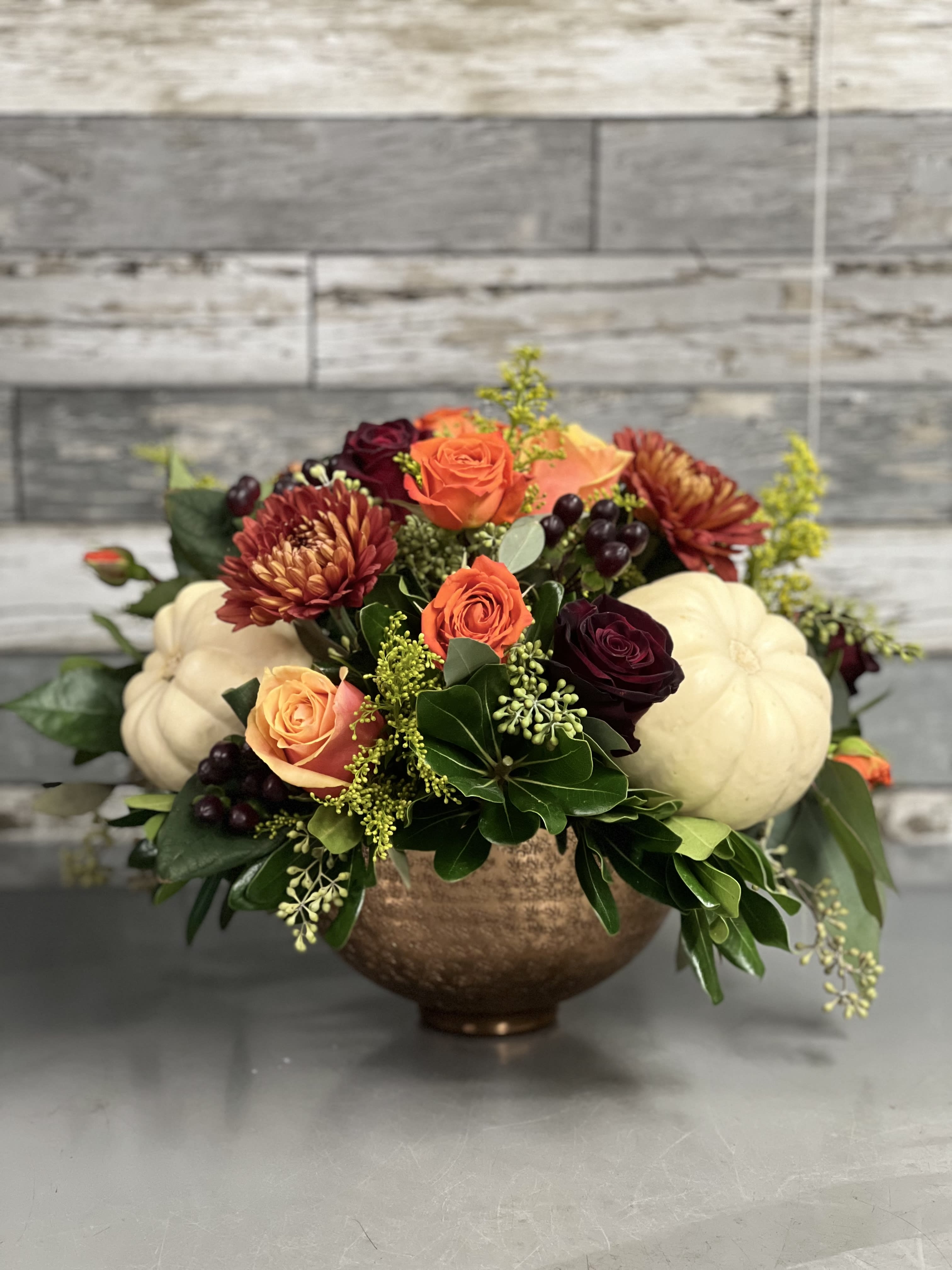 Hazel - Fall colors and flowers  arranged with small pumpkins in a copper container. Some flowers and colors may vary from image show.