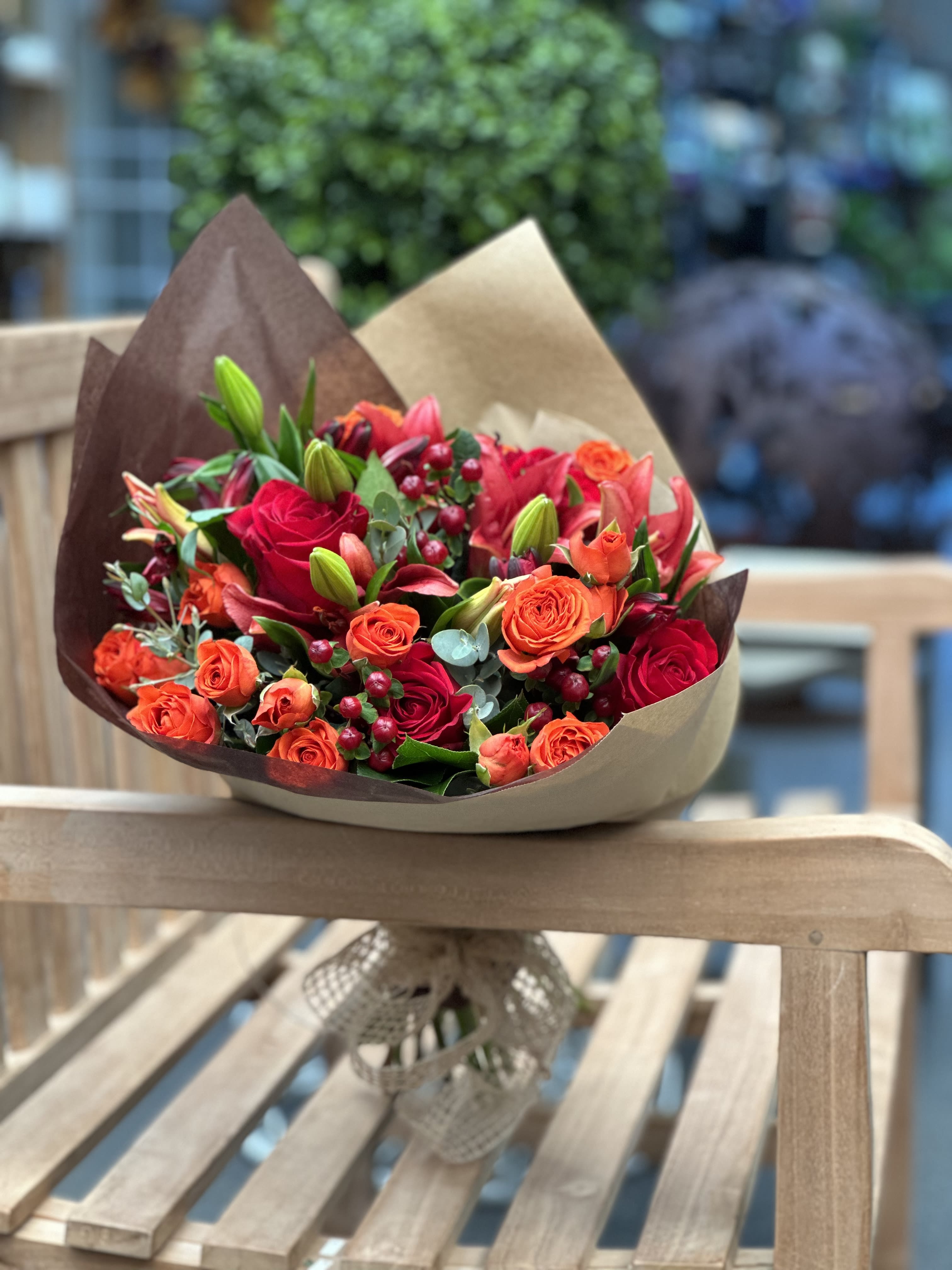 Amber Sun Signature Wrapped Bouquet - Assorted red and orange flowers with greenery (flowers may vary depending on availability but over all look and color scheme will remain)