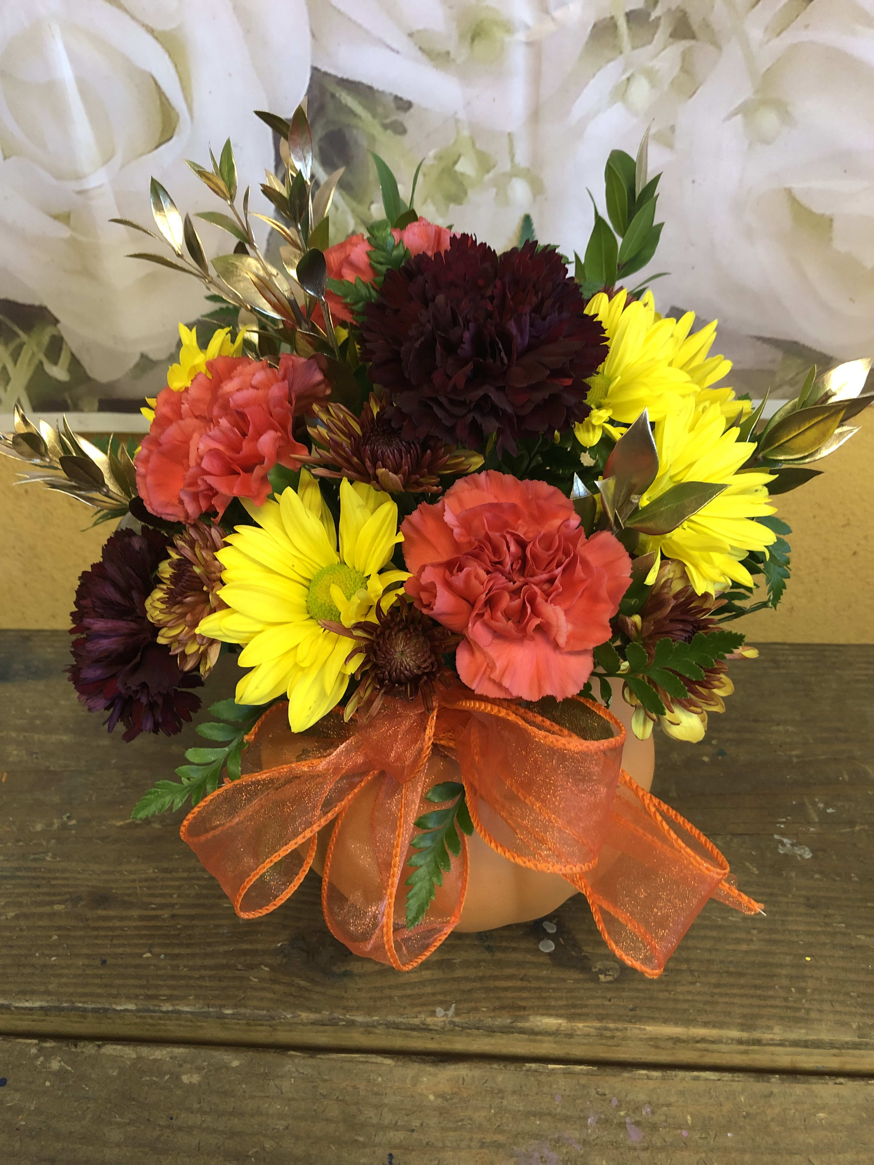 Pumpkins (Designer Choice) - Ceramic Pumpkin with fall color flowers,   Flowers to include carnations, cushion.  Standard price does not include roses.  4 Roses are included in the Deluxe price.  6 Roses are included in the premium price   The picture shown is the standard price.