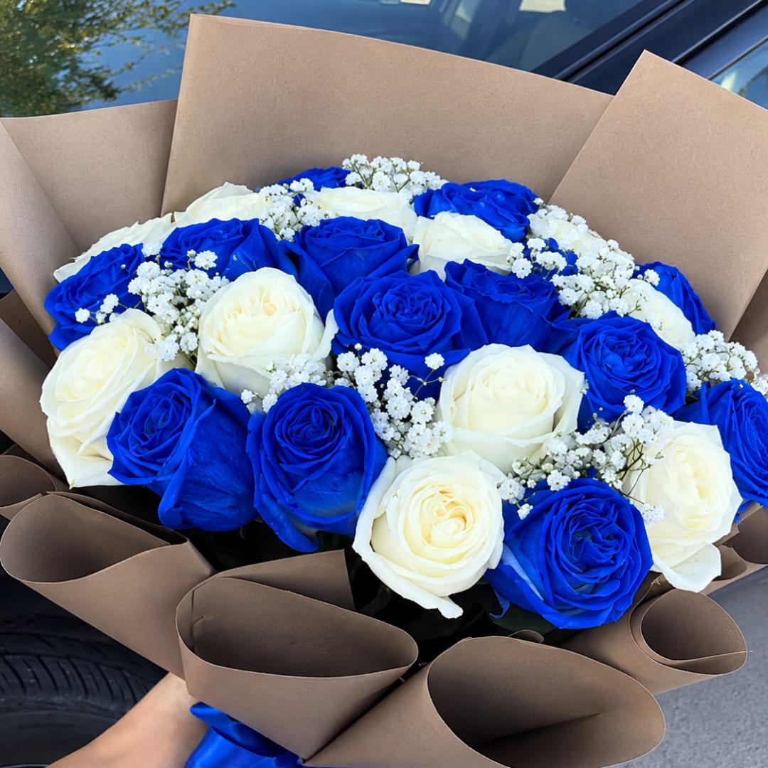 Bouquet of blue and white roses wrapped in brown paper