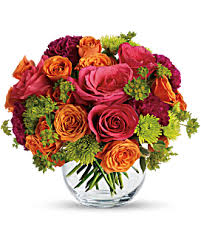 Bouquet of orange and pink roses in a clear glass vase