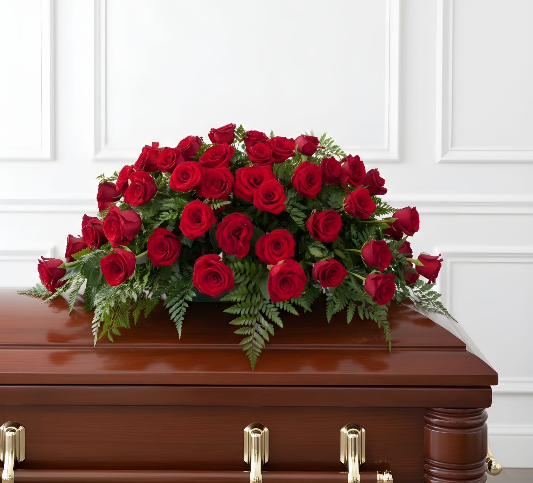 Red rose casket spray on a wooden coffin