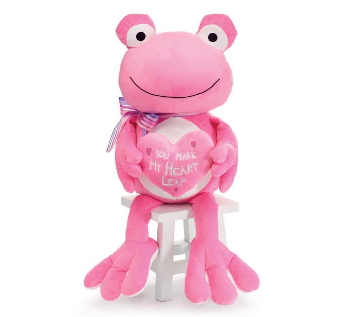 Pink plush frog holding a heart, seated on a small white stool