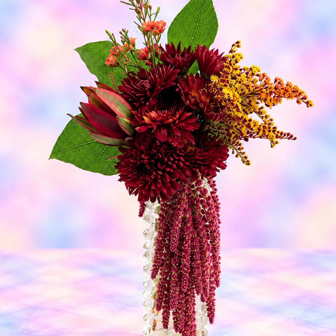 Deep red bouquet with yellow accents and large green leaves