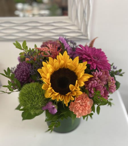 Fall Splendor - An autumn centerpiece with vibrant colors, sunflowers and local farm fillers.