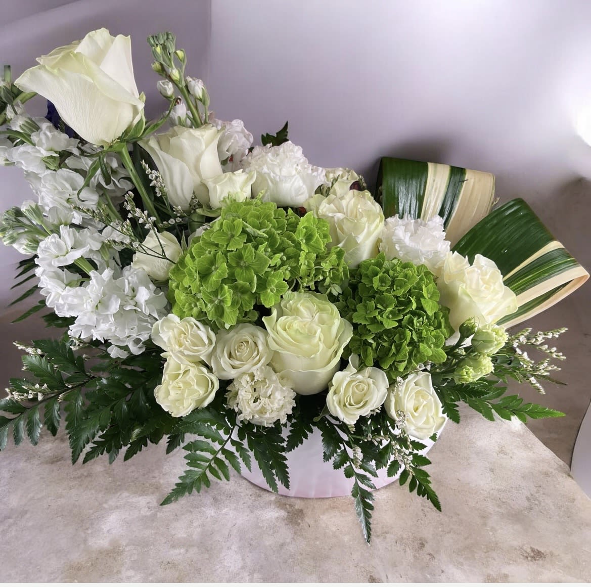 Wild Blooms - Disarrangement has hydrangea, roses, spray, roses, stock, aspidistra leaves, lisianthus and greenery. 