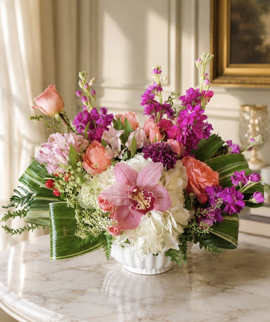 Pink and purple floral arrangement in a white vase