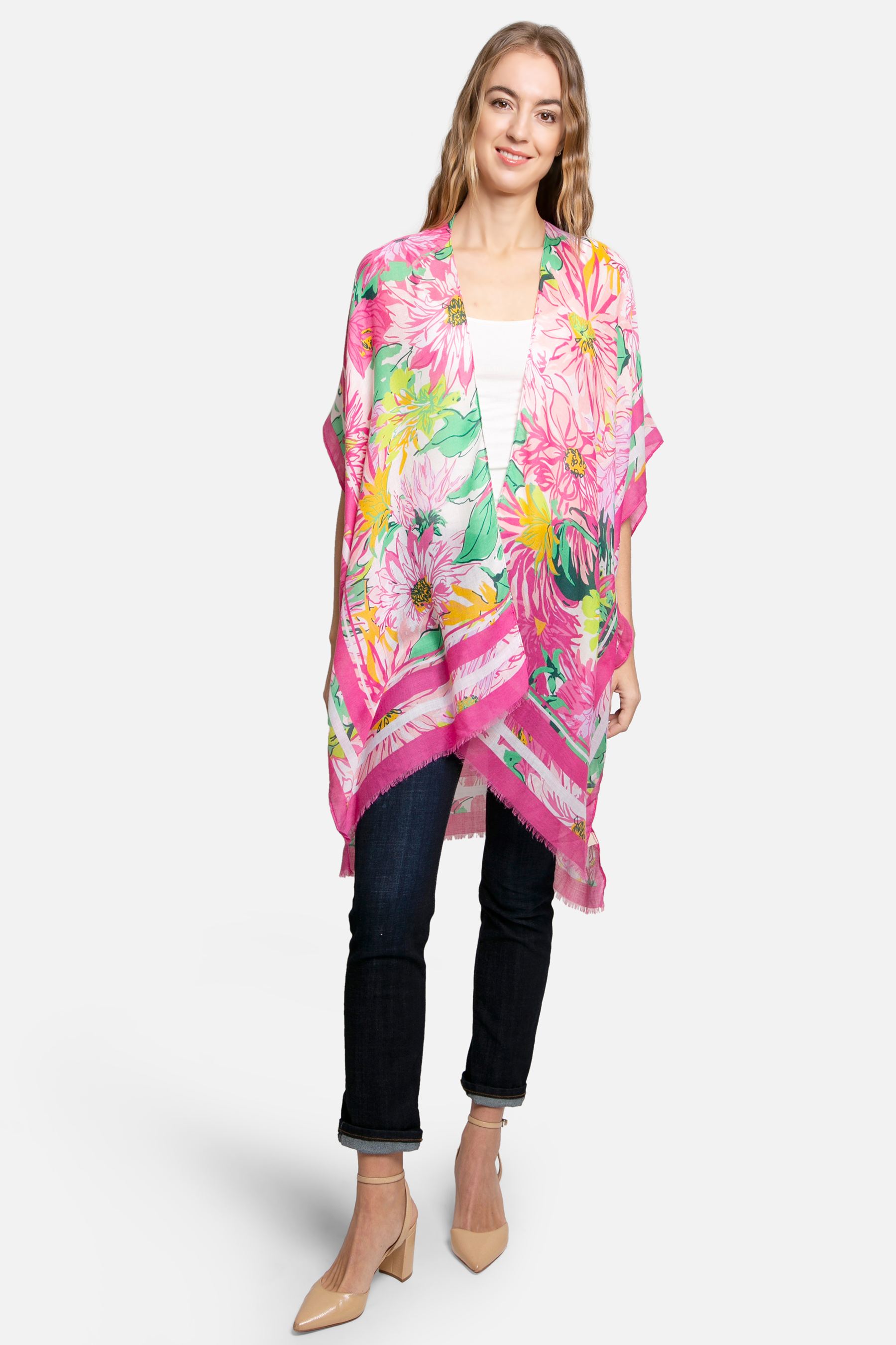 Woman wearing a bright pink floral kimono wrap over jeans and a white top