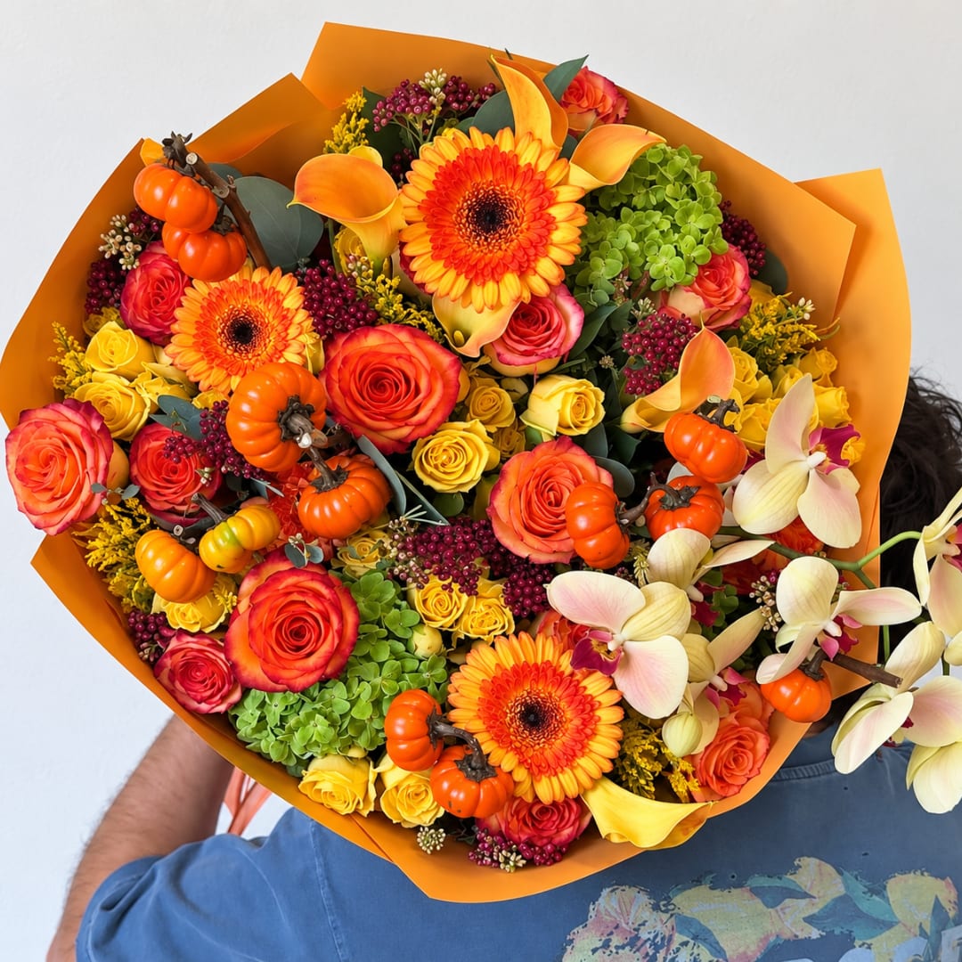 Bouquet of orange and yellow flowers with small pumpkins