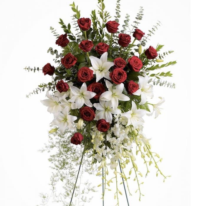 Standing floral spray with red roses and white lilies on a metal easel