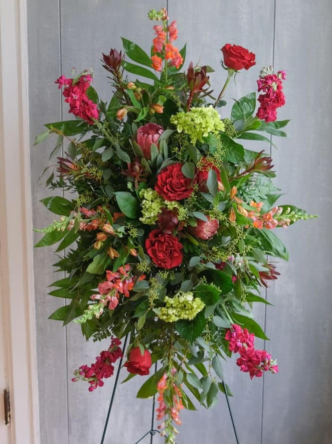 Tall standing floral spray with red roses and pink blooms
