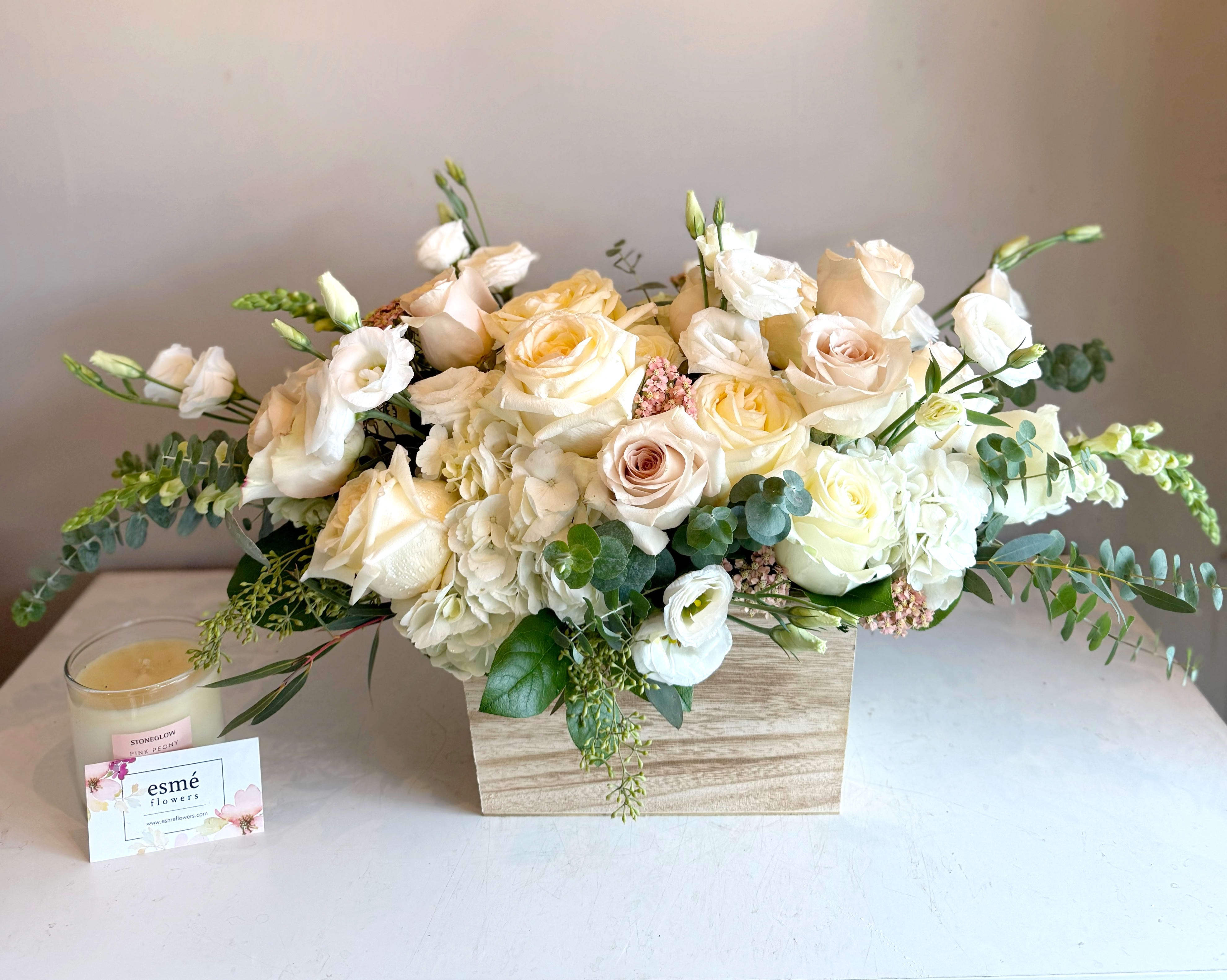 Cream and white rose arrangement in a wooden box with eucalyptus
