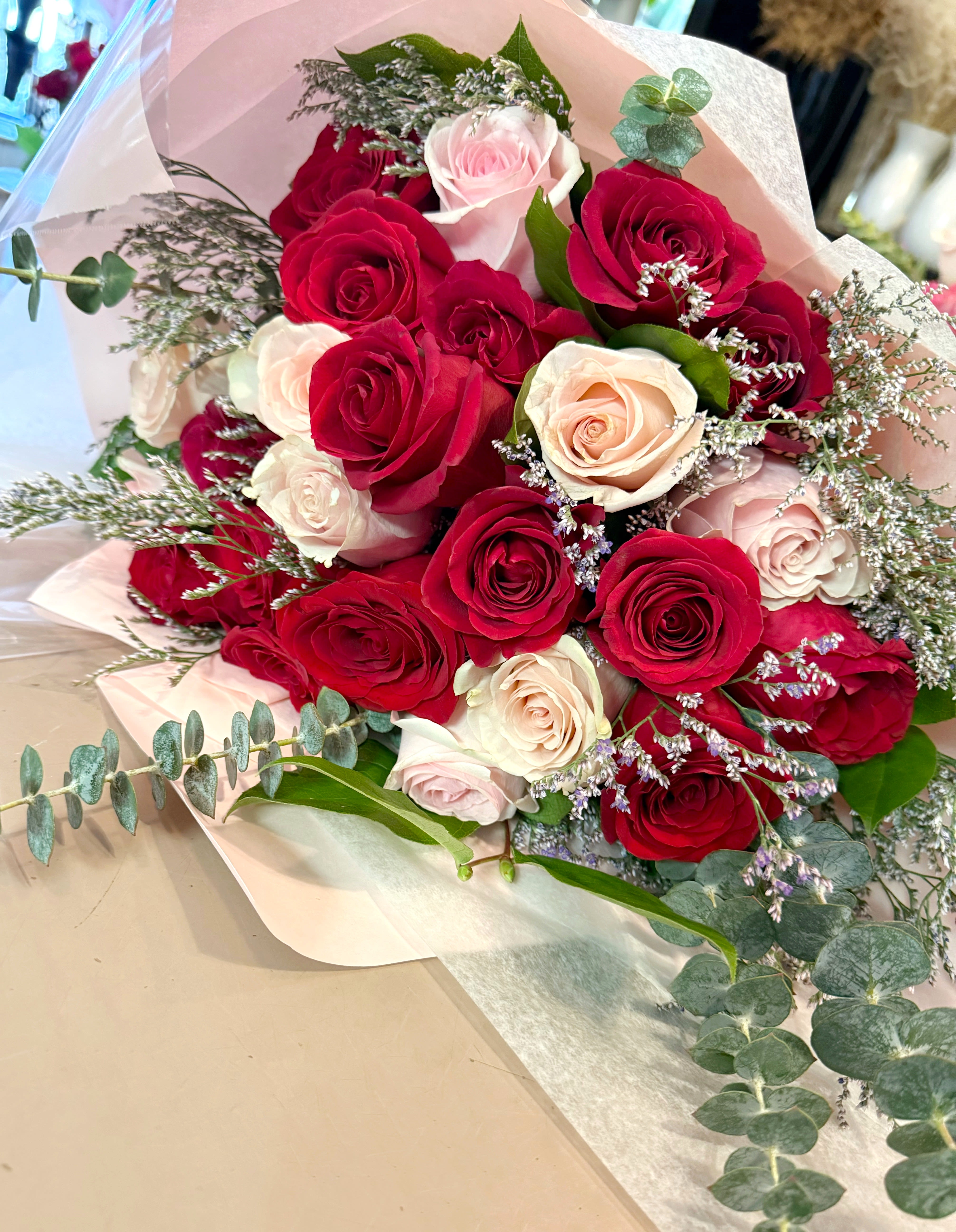 Bouquet of red and blush roses with eucalyptus and filler flowers
