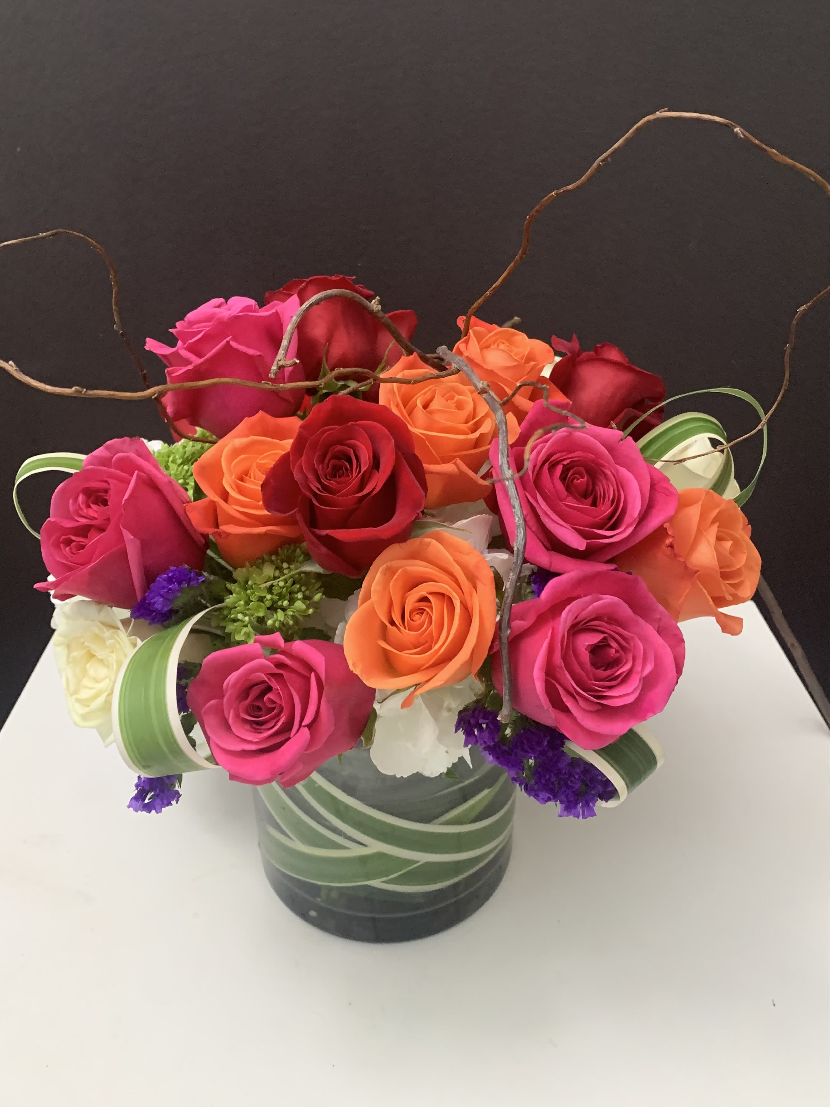 Mixed roses in a glass vase with curly branches