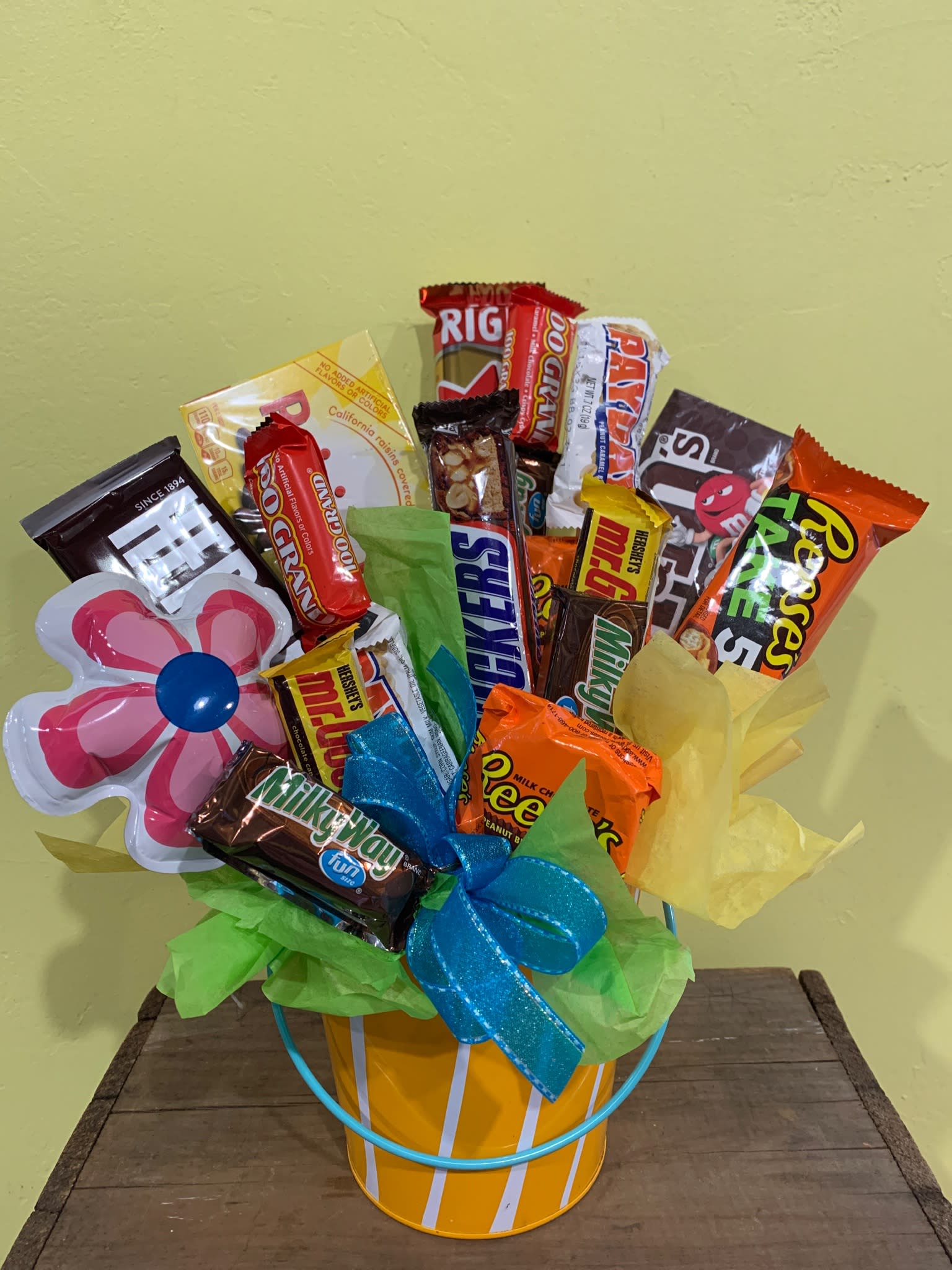 Candy bouquet in a striped bucket with a flower-shaped topper